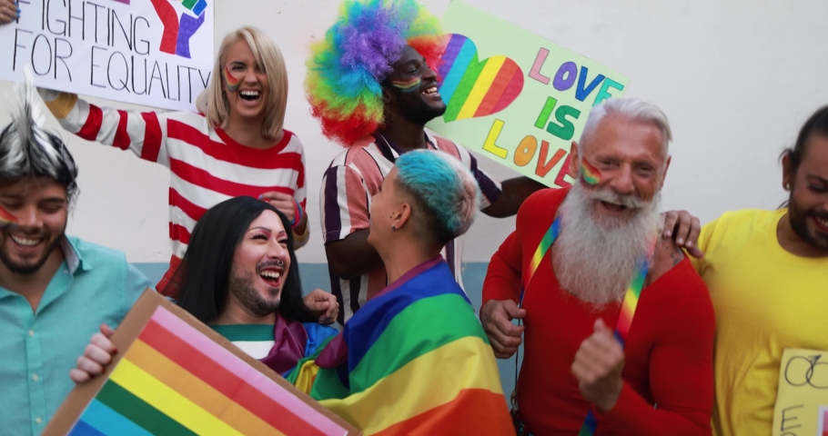 Gay people dance with banners and rainbow flags at pride party outdoor - Lgbt concept | Shutterstock HD Video #1062233578