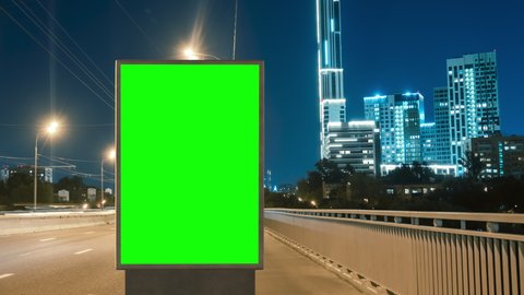 Modern billboard with a green screen for advertising on a busy highway with traffic, timelapse of traffic at sunset, Moscow, Russia