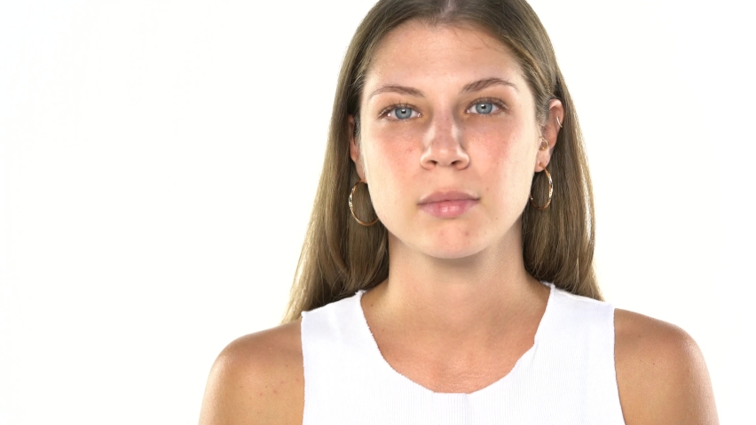young beautiful serious woman without makeup, begins to laugh on a white background