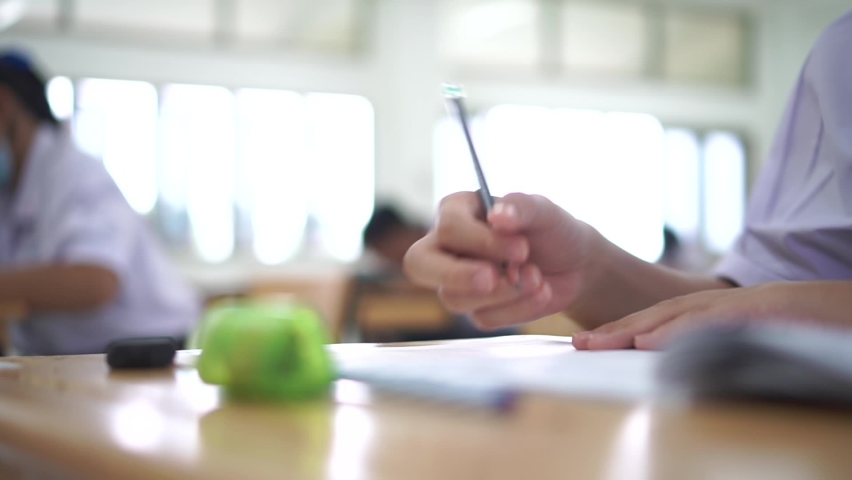 Asian Students testing in exam on exercise taking at high school or university in test room. Hands Writing document exams at campus classroom, back to school and evaluation measurement in education Royalty-Free Stock Footage #1062238915
