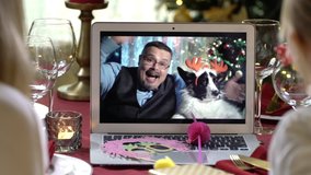 Mature man with a dog and family with a child celebrating Christmas using a video call. People greeting their relatives friends on Christmas eve online. Social distancing, self isolation quarantine - Powered by Shutterstock - Get 15% off with code: PIKWIZARD15