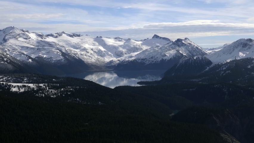 Beautiful snowy white mountains by the lake in Whistler, Canada -aerial