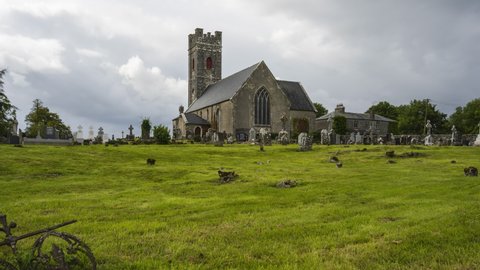 Time lapse of historical cemetery and medieval church in rural Ireland with passing clouds and sunshine.