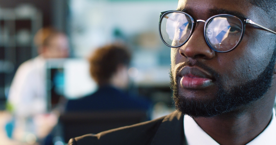 Close up portrait of handsome African American man in black suit and glasses. Young man with snow-white smile. | Shutterstock HD Video #1062248680