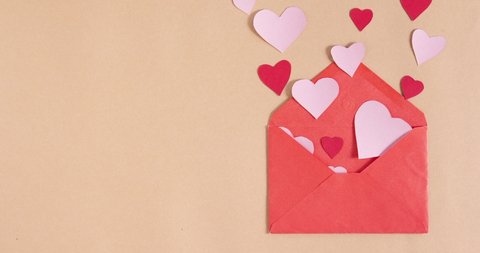stop motion animation with red paper envelope and flying hearts on beige background. copy space. love, valentines day and wedding greeting concept
