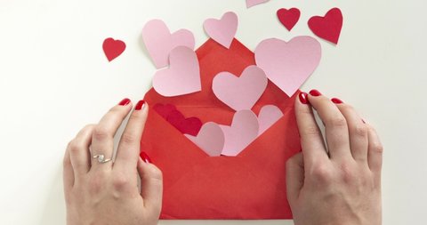 stop motion animation. Man hand give red envelope to woman hands, then hearts getting out of envelope. Love, valentine day, mothers day greeting card concept