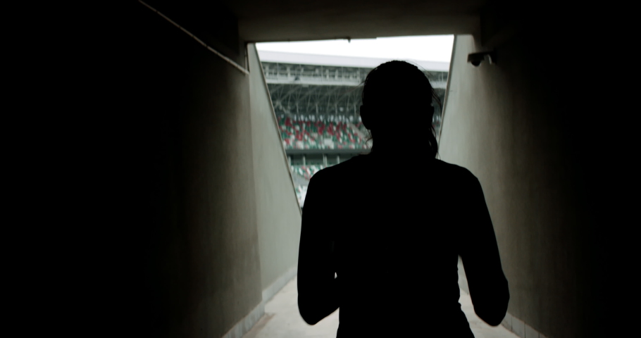 HANDHELD TRACKING Caucasian female athlete entering stadium before morning training. Shot with anamorphic lens