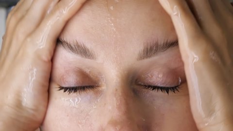 Close up of beautiful woman washes her long dark hair in shower, care, keratin mask, rinse shampoo and balm, strong hair, washing.