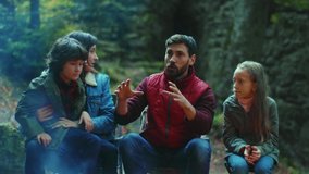 In evening family sits near campfire on autumn tells scary stories. Children with their parents are resting in the woods. Childhood relationship camping. Close up. Slow motion - Powered by Shutterstock - Get 15% off with code: PIKWIZARD15
