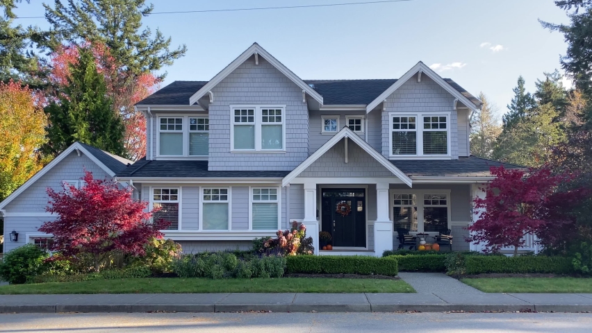 Establishing shot of two story light blue shingle luxury house with black door, red trees and nice landscape in Vancouver, Canada, North America. Day time on September 2020. Still camera view. H.264.