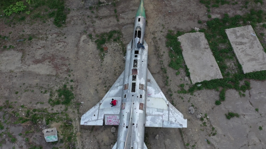 Close-up top view of an abandoned soviet military fighter su-15. children are sitting on the crashed plane.