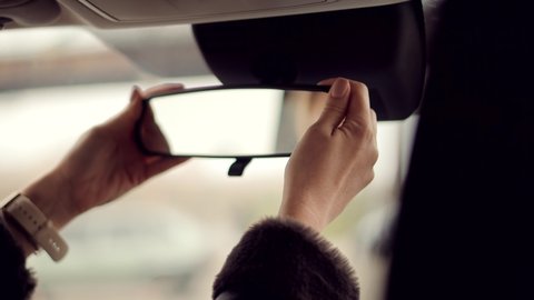 Woman Driver Adjusts Mirror In Car. Hand Preparing To Driving Car And Adjusting Rear View Mirror.Automobile Transportation Concept Independent Woman.Woman Driver Hand Prepare Driving SUV.Safety Adjust