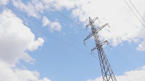 Electricity transportation line. High-voltage tower. Beautiful clouds on the background of Electricity pylons time lapse. Electricity transportation line. High-voltage tower