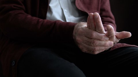 Aged man feeling pain in hand, inflammation of joints, rheumatoid arthritis