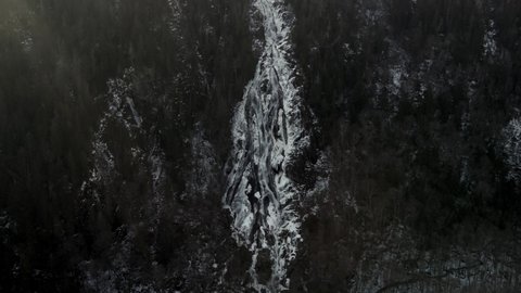 White Cascade Flowing Down From Forest Hills During Winter In Vallee Bras-du-Nord At Saint-Raymond, Canada. - Aerial Pullback Shot