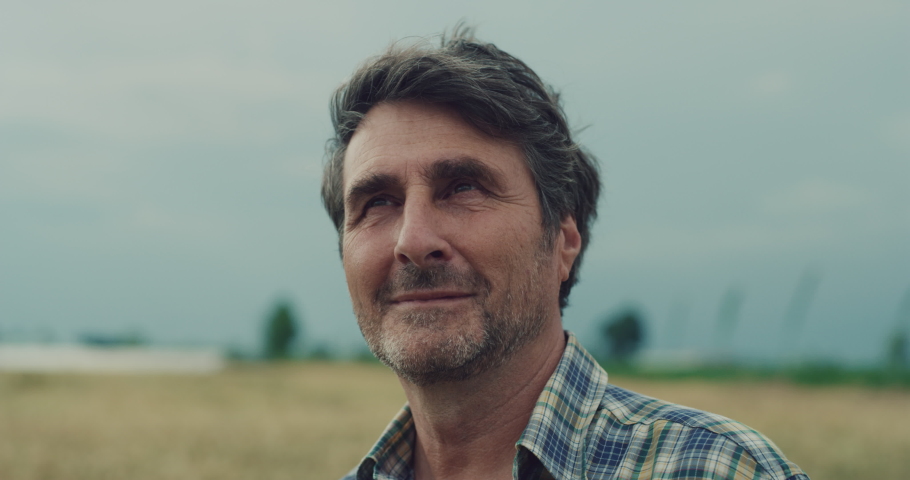 Cinematic shot of a mature male farmer satisfied with his work is enjoying a nature around him on a countryside farm fields. | Shutterstock HD Video #1062289258