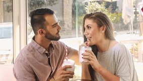4k wide video of multicultural dating couple drinking milkshakes in cafe. 