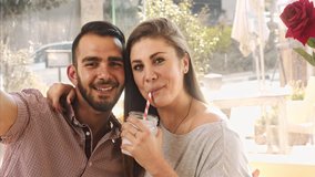 4k medium video of multicultural dating couple drinking milkshakes in cafe. 