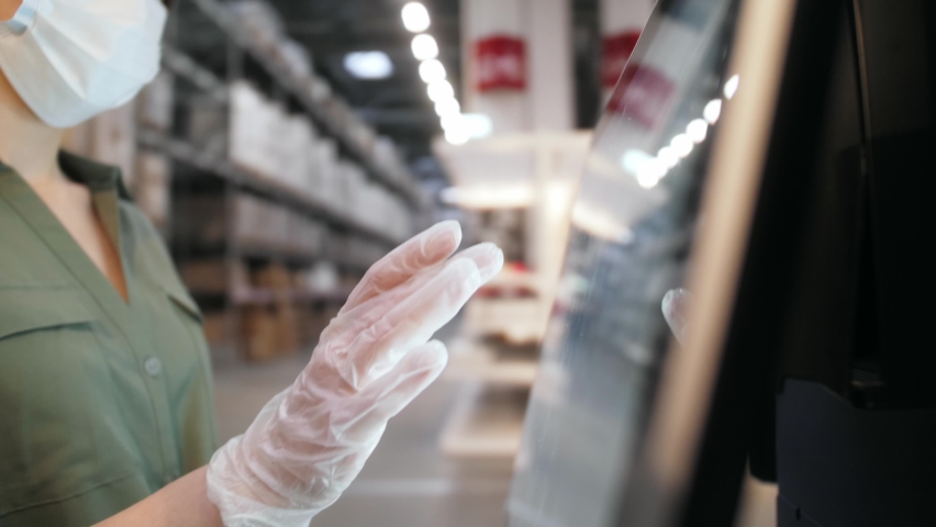 Worker of logistic warehouse working by touch screen display of interactive panel. Manager in medical mask and gloves working on warehouse during coronavirus pandemic. Technology concept. Royalty-Free Stock Footage #1062299926