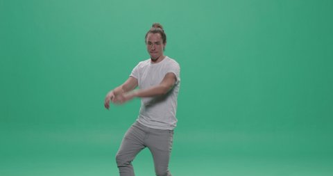 Studio, green screen, young man shows off modern dance moves, London