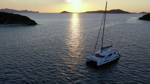 Aerial, pov, a sailboat anchored off the coast at sunset, Grenada