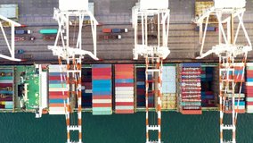 Shipping port and shipping container loading import export international logistics cargo transport by container ship open sea aerial view footage 4K video 