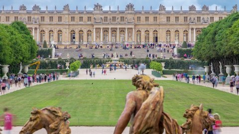 Famous palace Versailles with beautiful gardens timelapse from Apollo fountain. The Palace Versailles was a royal chateau. It was added to the UNESCO list of World Heritage Sites. Paris, France.
