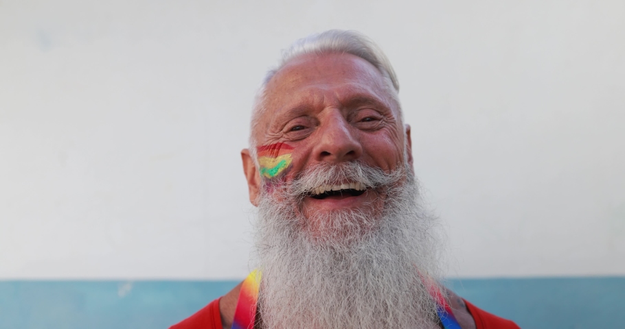 Senior gay man smiling in front of camera with rainbow colors painted on face - Slow Motion Royalty-Free Stock Footage #1062310789