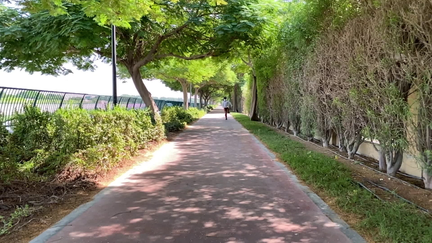 Slow motion of running a ten year old boy with mask. Child with mask in green nature background.