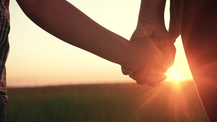 happy family mom and son hold hands close-up teamwork. mother and boy kid together hands at sunset. parent girl and child happy childhood lifestyle. happy family mother day concept Royalty-Free Stock Footage #1062315538