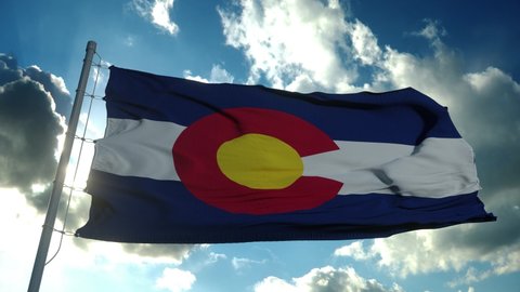 Colorado flag on a flagpole waving in the wind in the sky. State of Colorado in The United States of America