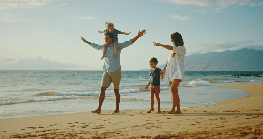 Happy young family walking on the beach together at sunset Royalty-Free Stock Footage #1062328966