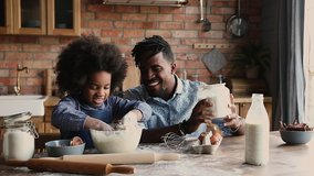 African dad with dreadlocks pour flour while curly haired daughter knead dough in bowl, family prepare surprise sit at dining table in kitchen. Spend time together develop kid, pleasant chores concept - Powered by Shutterstock - Get 15% off with code: PIKWIZARD15