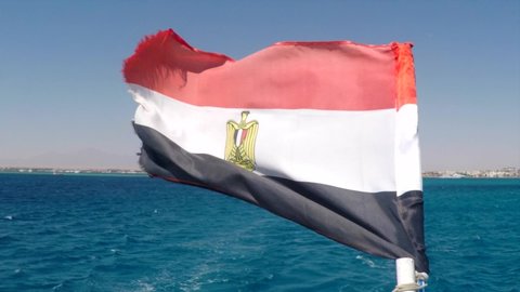 Egyptian flag flies at the stern of the yacht in the background of the turquoise sea, Film grain applied 