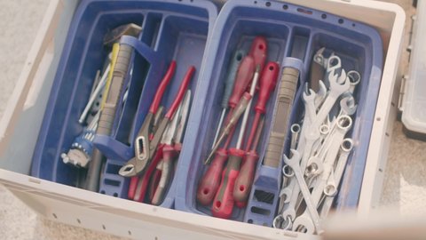 A mechanic's tool box with wrenches, srew drivers and forceps. Tilting shot from above. Shot in 4K.