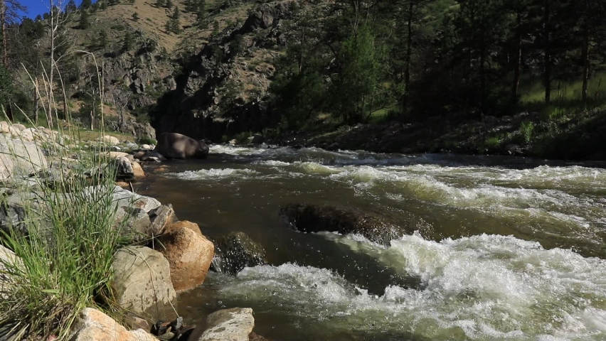 River rapids on the Big Thompson River of Colorado.  Snow melt from the Rocky Mountains rushes downstream towards the Front Range.Rocks, boulders, canyon views and whitewater.