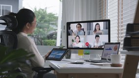 Zoom in business woman talking about sale report in video conference.Asian team using laptop and tablet online meeting in video call.Working from home, Working remotely and Self isolation at home
