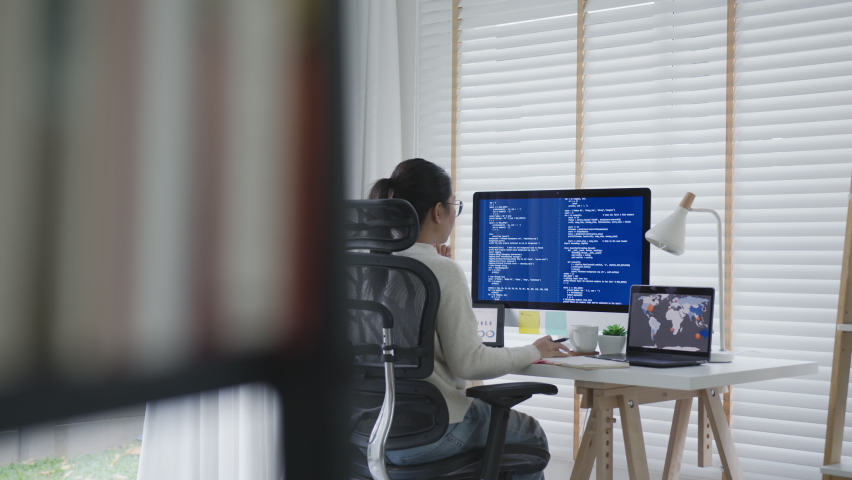 Back rear view of young asian woman, freelance data scientist work remotely at home coding programming on Big data mining, AI data engineering, IT Technician Works on Artificial Intelligence Project. Royalty-Free Stock Footage #1062364000