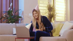 Birthday girl attractive blondie celebrating distant birthday videocalling her family showing amazing pet bengal cat having fun staying home for quarantine.