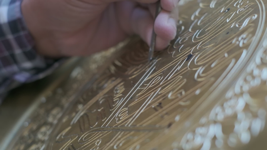 Bukhara master engraves patterns on a tray. Close up, slow motion Royalty-Free Stock Footage #1062368971