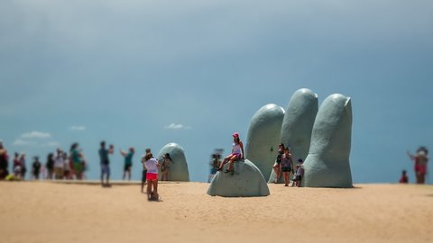 Punta del Este, Uruguay - January 20: Tilt shift time lapse sequence showing tourists taking photos at the popular The Hand (Spanish: La Mano ) outdoor sculpture in Punta del Este, Uruguay.