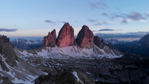 Drone aerial flying near Tre Cime di Lavaredo mountain in Sexten Dolomites Italy at sunset. Hiking nature epic landscape in South Tirol. European Alps wanderlust.