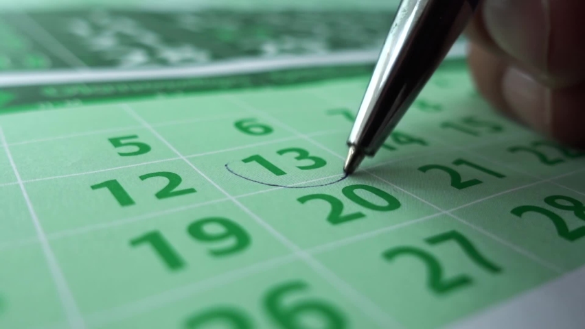 Close up horizontal video of person checking a date on the calendar. Shallow depth of field. Planning with a note reminder memo. | Shutterstock HD Video #1062398311