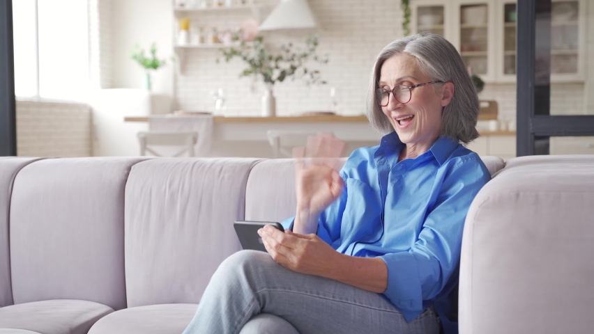 Old senior middle aged woman grandmother holding cell phone video conference calling in mobile app talking with social distance family or doctor in virtual online chat meeting on smartphone at home. Royalty-Free Stock Footage #1062406864