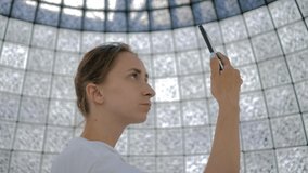 Portrait of young woman using smartphone against wall with many qr codes at modern futuristic exhibition or museum. Education, technology, entertainment concept - Powered by Shutterstock - Get 15% off with code: PIKWIZARD15