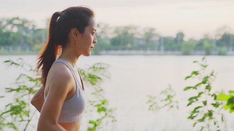 Asian young beautiful woman running for health in the evening sunset on street in public park. The athlete fit and firm girl exercising by jogging workout sport outdoor for her healthy wellness.