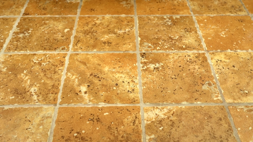 4k shot of square floor tiles installed on bathroom floor. Footage of flooring is slow motion panning shot