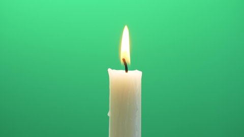 Close-up single candle flame isolated on chroma key green screen background