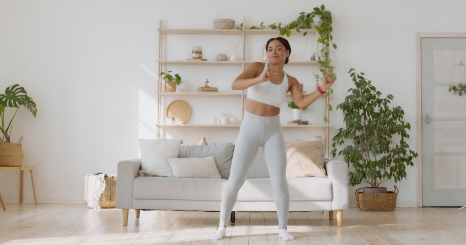 Training muscles priests and legs in dance. Energetic african american lady dancing after fitness workout at home, enjoying her lifestyle, slow motion | Shutterstock HD Video #1062422770