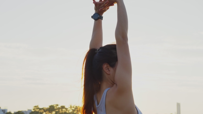 New normal sport outdoor, young Asian fit sport woman stretching her body warm up before workout outdoor. The girl in sportswear exercises outside in the evening sunset for health and wellbeing. Royalty-Free Stock Footage #1062424663